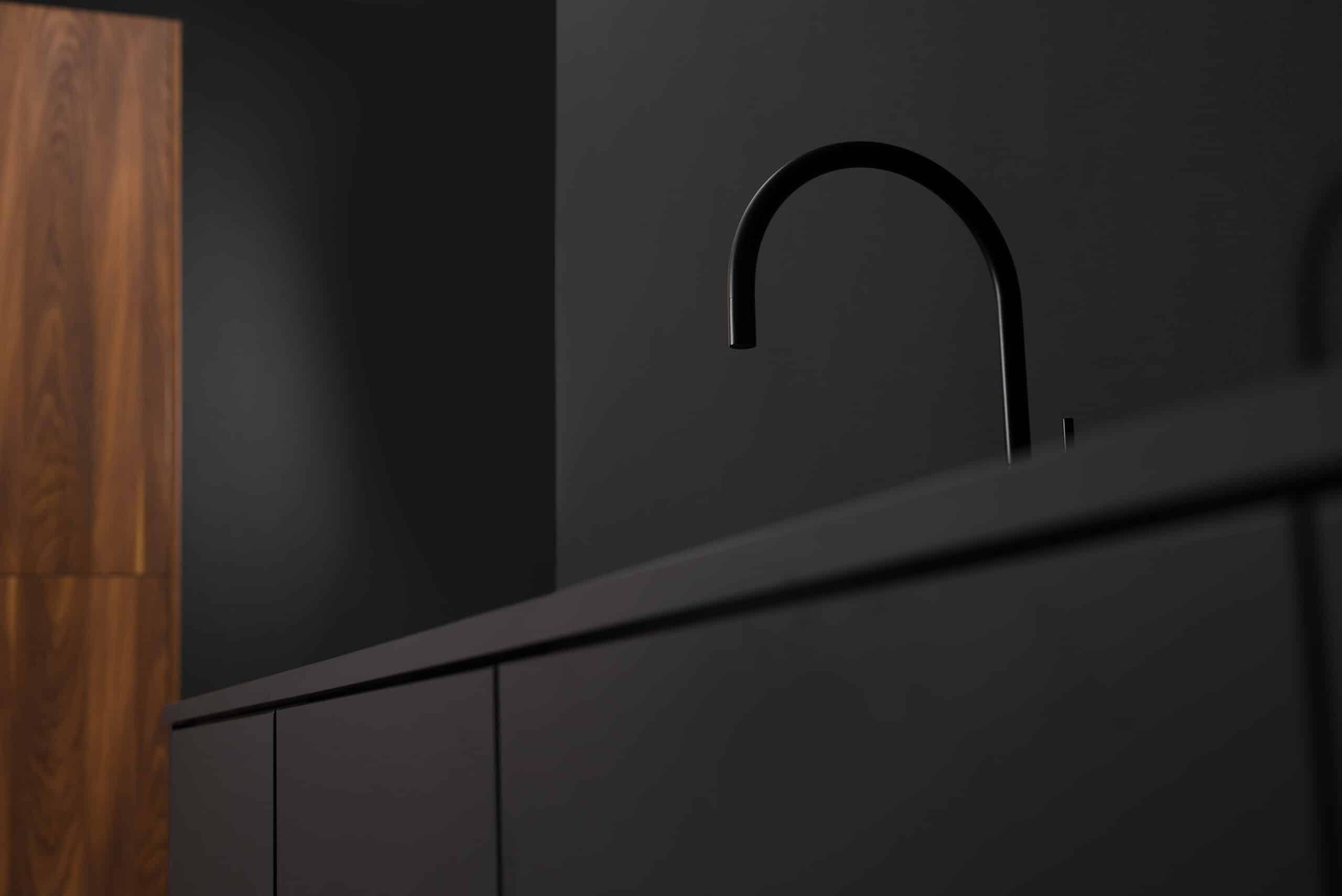 Minimalistische keuken met matzwarte kraan en donkere kastfronten, gecombineerd met houten accenten