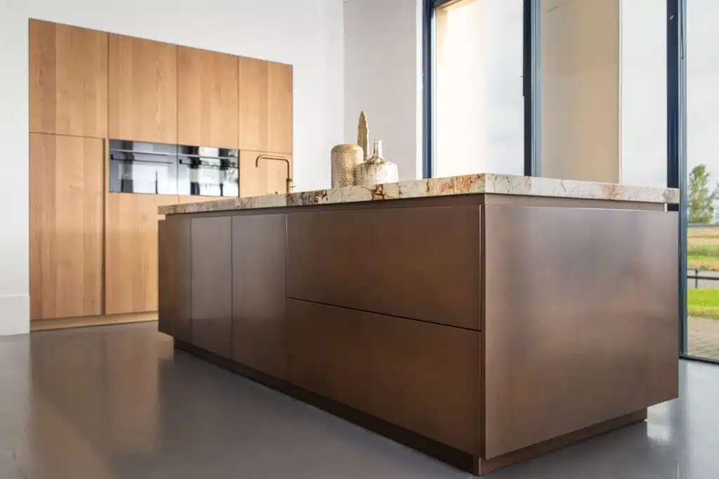 overzichtsfoto van een luxe keuken in heteren met bronzen en houten details
