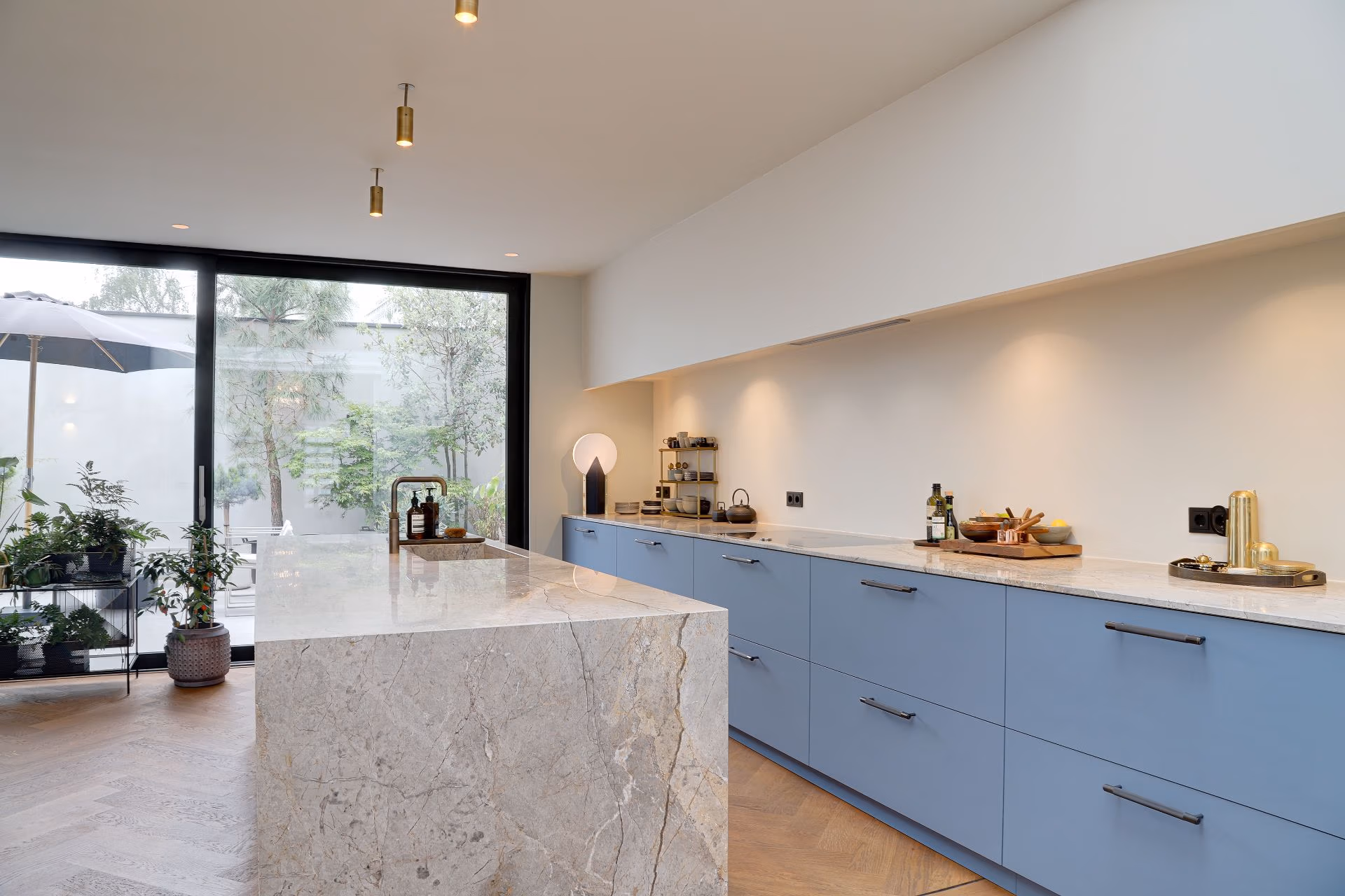 blauwe fenix keuken met marmeren blad en visgraat vloer